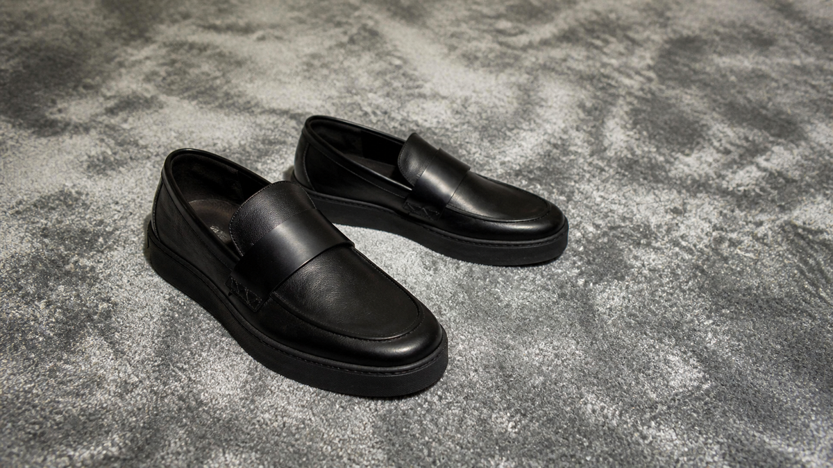 Wisteria Fujiwara BRIDGE black loafer on silver-gray carpet