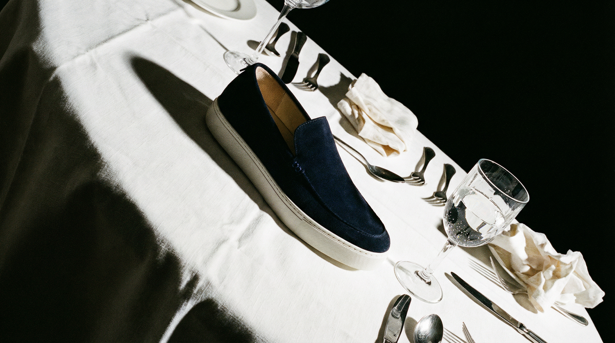 Navy suede slip-on on white restaurant tablecloth